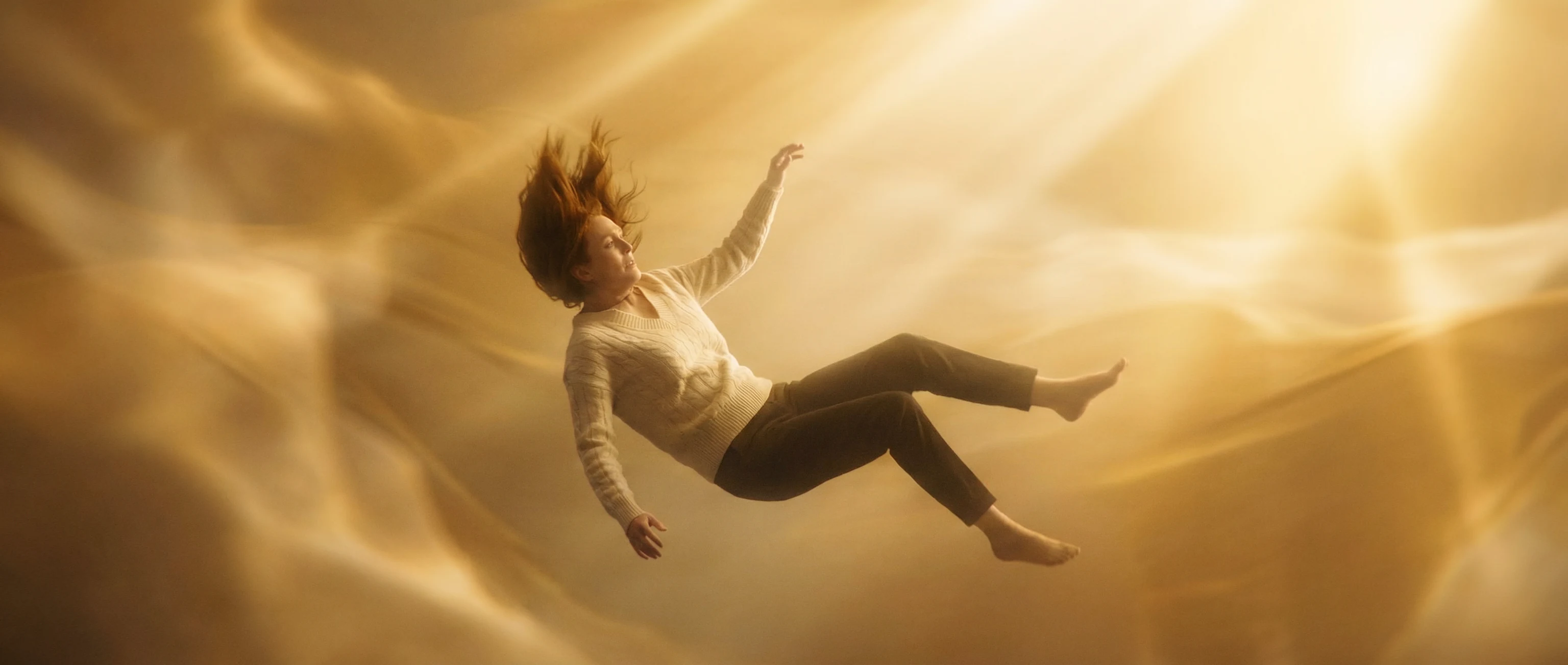 Emma floating in a golden abstract memory space